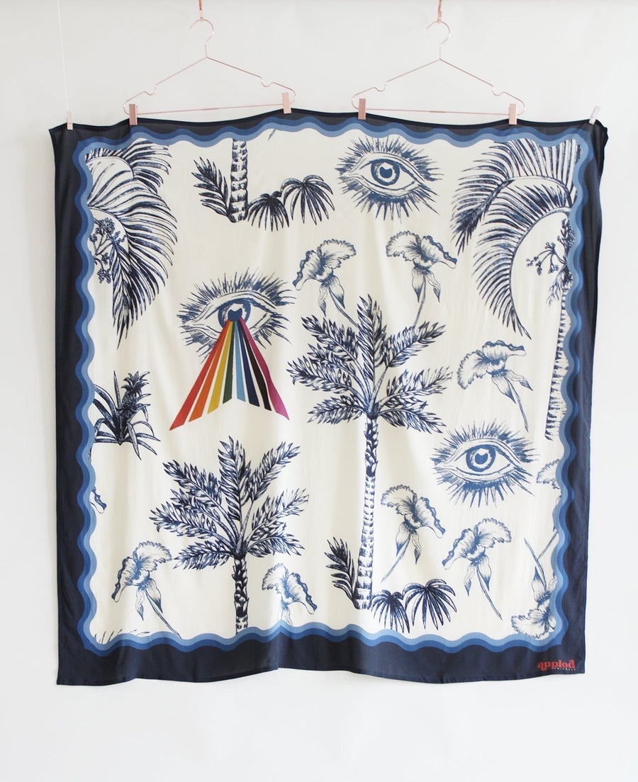 Beautiful pareo in navy and bone colored hues. Print includes a mystic third eye, palms, and a splash of muted rainbow colors. 